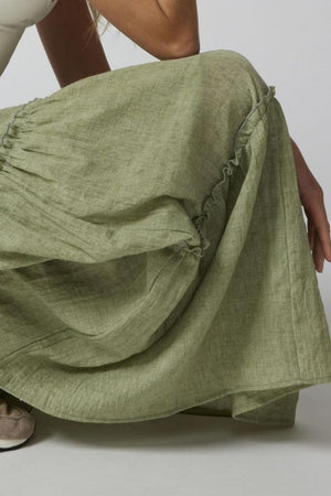 Tiered cotton maxi skirt in matcha green with ruffled details and a flowing silhouette.