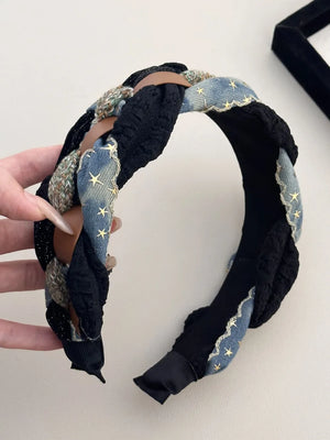Denim starburst braided headband in black with brown leatherette details and textured fabric.