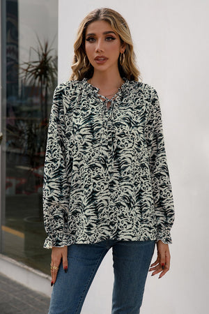 Animal print blouse with ruffle neckline and tie detail, long sleeves.