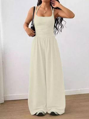 Apricot ruched wide-leg jumpsuit with spaghetti straps and a square neckline.