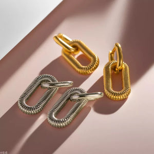 Gold and silver sculptural link drop earrings with ribbed texture.