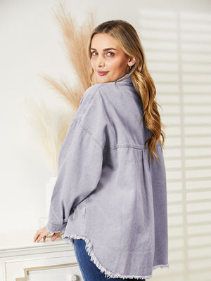 Distressed denim overshirt in lilac with raw hem and buttoned front.