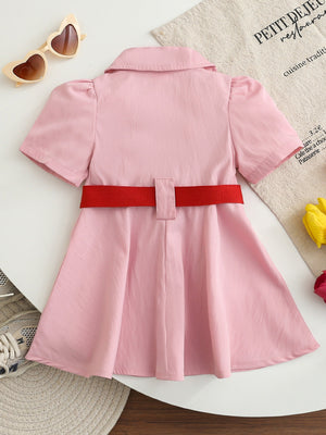 Pink cotton blend baseball dress for kids with short sleeves, collared neckline, and red adjustable belt.