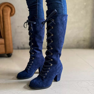 Blue suede lace-up block heel boots with silver eyelets.