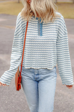 Textured stripe henley sweater in dusty blue with button placket and lettuce hem.