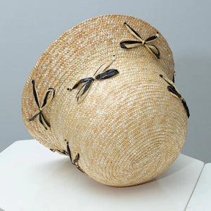 Straw bucket hat in natural with black and tan bowknot details.