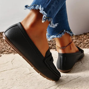 Black loafer flats with subtle stitching and a low heel.