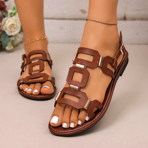 Brown cutout open-toe sandals with gold hardware detail.