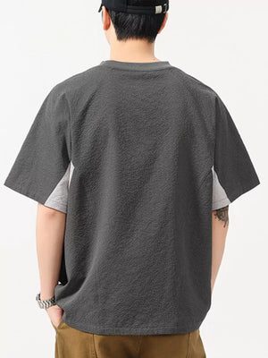 Men's dark gray textured t-shirt with contrast light gray panels and crew neck.