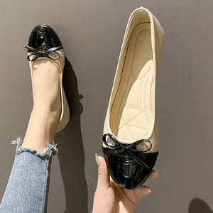 Patent bow ballet flats in black and white with a cap toe detail.