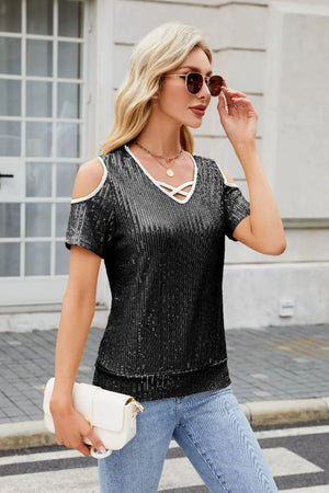 Black sequin cold shoulder blouse with white trim and crisscross neckline detail.