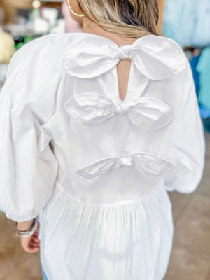 White babydoll blouse with three back bow details and balloon sleeves.