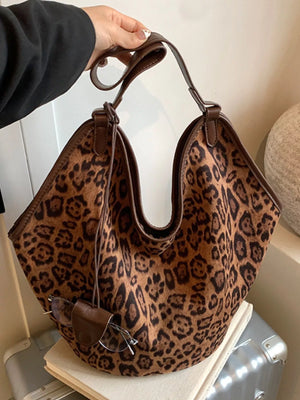 Chic leopard print tote bag with brown trim and shoulder straps. Includes a small leather pouch.