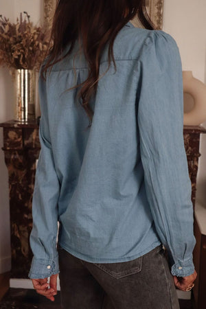 Indigo button-up blouse with puff sleeves and button cuffs.