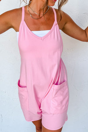 Pink spaghetti strap romper with patch pockets and V-neckline.