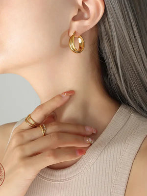 Gold double-band hoop earrings with a sculpted design.