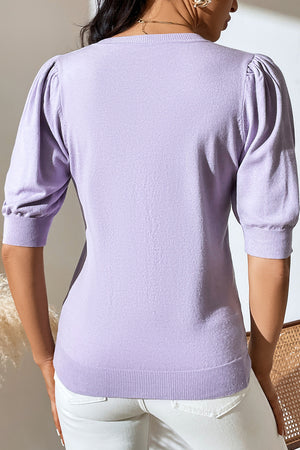 Lilac knit sweater with puff sleeves and ribbed cuffs and hem.