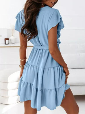 Light blue polyester mini dress with ruffle sleeves, tie waist, and tiered skirt.