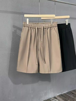 Khaki chino shorts with drawstring waist and pleats, cotton blend.