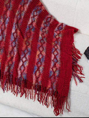 Textured knit cape in terracotta with diamond pattern and fringe detail.