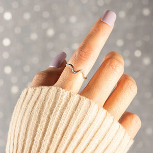 Serpentine diamond contour ring in silver with a wavy design.
