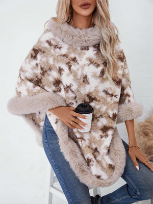 Faux fur trimmed camo poncho in chocolate with a fuzzy texture and relaxed fit.
