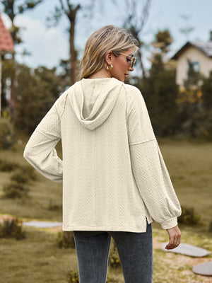 Cream textured knit hoodie with balloon sleeves and a cable knit pattern.
