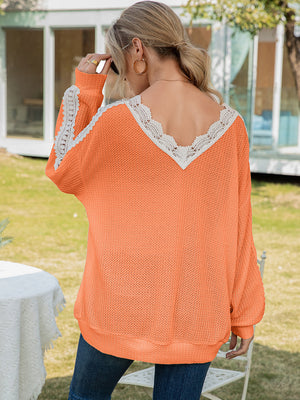 Orange waffle knit top with V-neck lace trim and long sleeves.