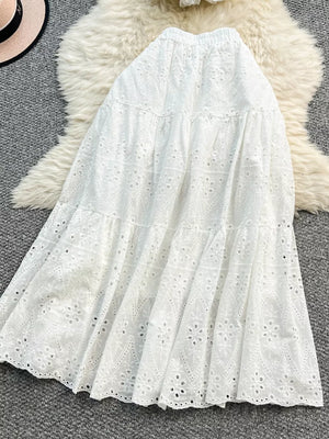 White eyelet maxi skirt with tiered ruffles and elastic waistband.