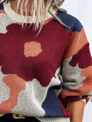 Abstract floral knit sweater with round neck in burgundy, cream, navy, and orange tones.