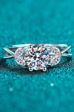 Silver moissanite ring with a large round center stone and leaf-shaped accents.