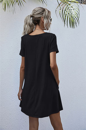 Black relaxed tee dress with short sleeves and side pockets, shown from the back.