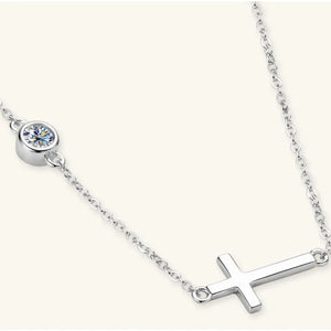 Silver asymmetrical cross pendant necklace with a single bezel-set crystal accent.