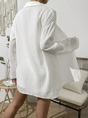 White textured gauze shirt with buttoned front and long sleeves, styled casually.
