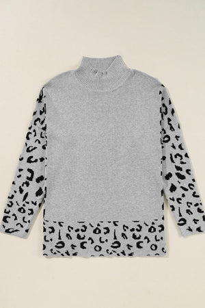 Gray knit sweater with mock neck and asymmetric leopard print panels on sleeves and hem.