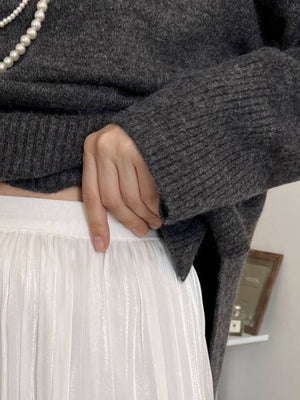 Flared sleeve ribbed turtleneck knit sweater in Floral Gray, styled with a white pleated skirt.