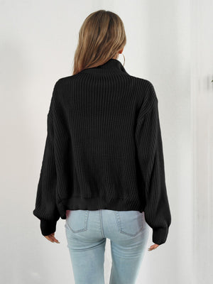 Black ribbed knit zip-up sweater with a mock neck and balloon sleeves.