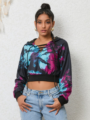 Multicolor tie-dye crop hoodie with lace-up neckline and black cuffs.