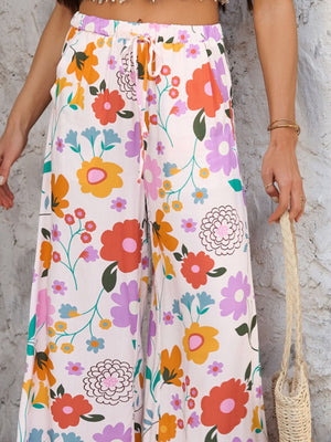 Geometric print wide-leg trousers with drawstring waist in multicolor floral pattern.