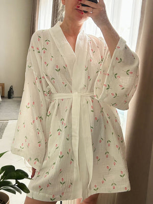White cotton robe with pink floral print, tie waist, and wide sleeves.