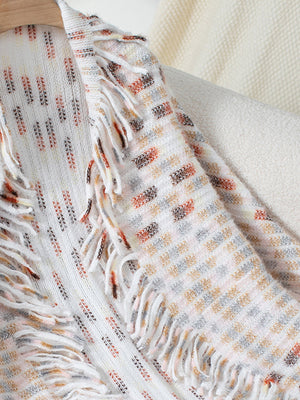 Textured fringe shawl cardigan in white with multi-color woven pattern and fringe details.