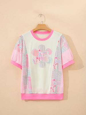 Maternity t-shirt with crew neck, short sleeves, floral patchwork pattern, and pink accents.
