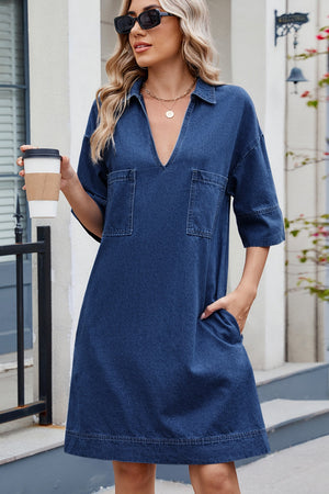 Dark denim collared mini dress with V-neck, short sleeves, and two chest pockets.