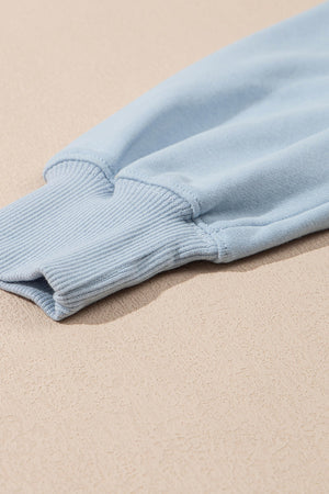 Light blue sweatshirt sleeve detail with ribbed cuff and stitching