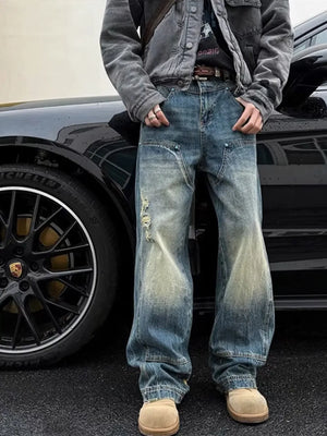 Distressed wide-leg jeans in dark wash denim with faded details and a relaxed fit.