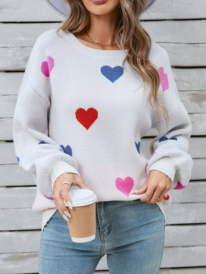 White knit sweater with pink, blue, and red heart motif, bubble sleeves