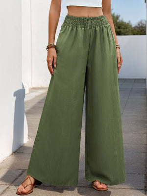 Moss green textured palazzo trousers with elastic waist and wide legs.
