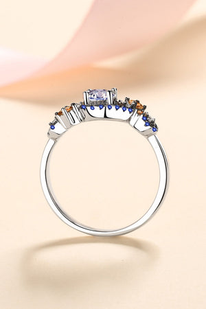 Silver ring with a central gemstone and blue and orange accent stones