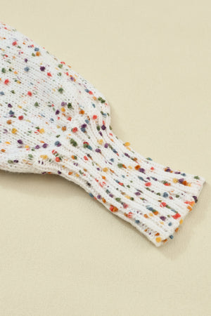 Speckled puff sleeve knit sweater in cream with colorful flecks and ribbed cuffs.