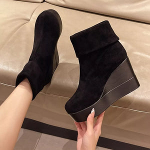 Black suede wedge boots with a folded cuff and platform sole.